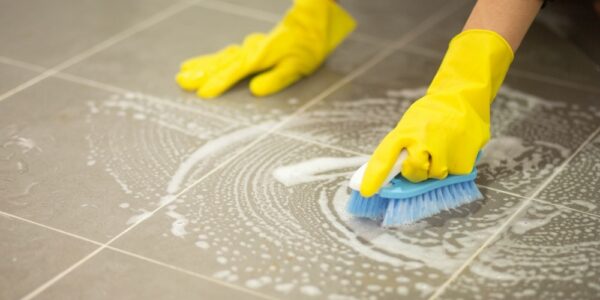 Woman's,Hand,Wearing,Yellow,Rubber,Gloves,Using,A,Brush,To