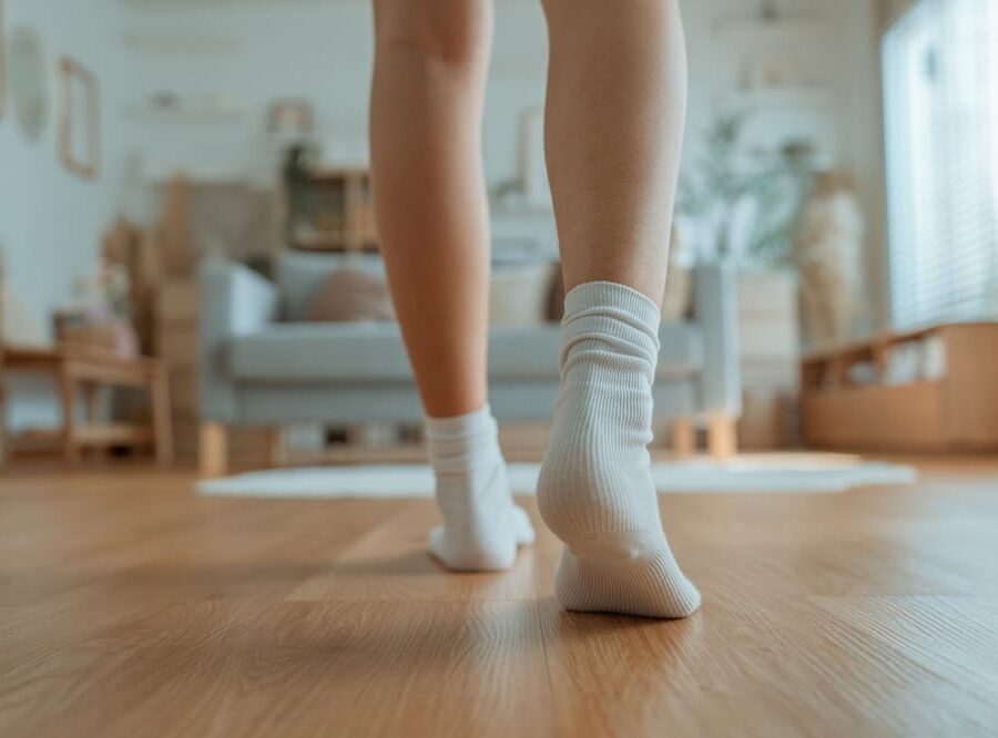 Closeup,Foot,Of,Young,Woman,With,Sock,Walking,On,Wooden